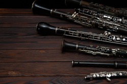 Woodwind instruments lie on a wooden surface