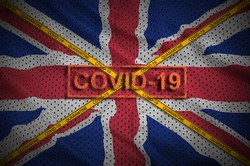 Great britain flag and Covid-19 stamp with orange quarantine border tape cross. Coronavirus or 2019-nCov virus concept