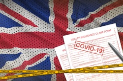 Great britain flag and Health insurance claim form with covid-19 stamp. Coronavirus or 2019-nCov virus concept