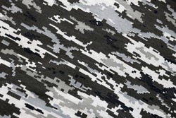 Fabric with texture of Ukrainian military pixeled camouflage. Cloth with camo pattern in grey, brown and green pixel shapes. Official uniform of Ukrainian soldiers close up