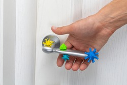 Coronavirus and other germs on the doorknob. A man with his hand grabs an infected handle.