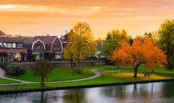 Leerdam the netherlands a typical dutch city view from the park with water, road and grass at sundown in autmun season.