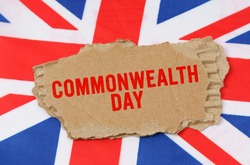 Holidays of the UK. Against the background of the flag of Great Britain lies cardboard with the inscription - Commonwealth Day