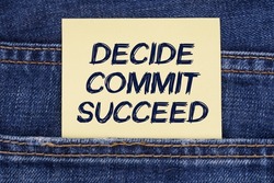 Economy and education concept. There is a paper sticking out of a jeans pocket with the inscription - Decide Commit Succeed