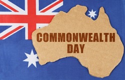 National concept of Australia. On the flag of Australia lies the contour of the map of the country with the inscription - Commonwealth Day