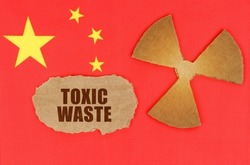 The concept of industry and radiation. On the flag of China, the symbol of radioactivity and torn cardboard with the inscription - Toxic waste