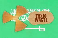The concept of industry and radiation. On the flag of Saudi Arabia, the symbol of radioactivity and torn cardboard with the inscription - Toxic waste