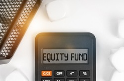 Business concept. On the table are white cubes, a black basket and a calculator with the inscription - EQUITY FUND
