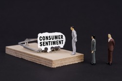 Business trap, crisis concept. Figures of businessmen stand near a mousetrap, the bait in which is torn paper with the inscription - Consumer Sentiment