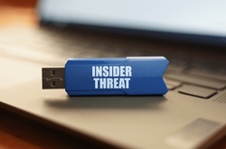 Computer and security concept. On the laptop keyboard is a flash drive with the inscription - INSIDER THREAT