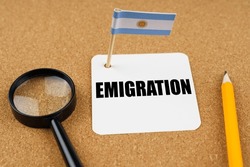 On the table is the flag of Argentina, a pencil, a magnifying glass and a sheet of paper with the inscription - Emigration