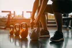 fitness ,workout, gym exercise ,lifestyle  and healthy concept.Woman in exercise gear standing in a row holding dumbbells during an exercise class at the gym.Fitness training with kettlebell in sport 