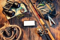 Fishing tackle on a wooden background. Fishing composition with spinning rod and reel. Spinning and tools. Copy space.