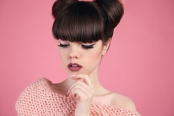 Beauty makeup. Fashion teen girl model. Brunette with matte lips and hairstyle posing over studio pink background.