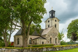 Medieval church located in Lundby, Sweden. In  vibrant summer sunlight and overcast sky