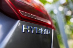 Close-up of Hybrid icon on car body. Environment concept. Ecological transport.
