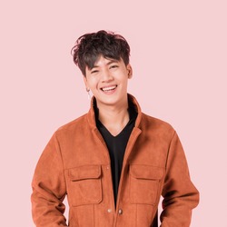Portrait of happy asian handsome young man in fashionable clothing with standing and smiling isolated on pink background.
