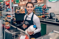 Portrait of beautiful smiling cashier working at a grocery store.