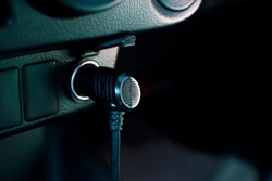 The 12 volt car power outlet socket with the adapter plug hold on the socket in a car.