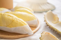 Close up durian in packaging on wooden dish with durian peel. Durian king of fruit. Tropical fruit.