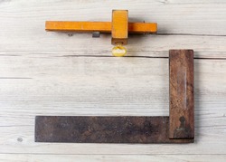Antique set square and mortise gauge isolated on a light wooden background