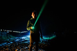 Tourist have rest in camp, lighting at the sky with green laser pointer. Grainy effect cinematic style.