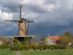 Typical dutch rural scenery with traditional windmill in the village of Terheijden, Province North Brabant