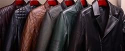 New collection of different color spring leather jackets for men. Colorful background of modern spring, autumn outerwear. Close up. Seasonal clothing in store on sale.