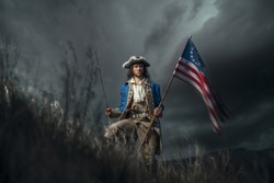 American revolution war soldier with flag of colonies and saber over dramatic landscape. 4 july independence day of USA concept photo composition: soldier and flag.