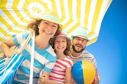 Happy family on summer vacation. Low angle view portrait of happy people against blue sky background