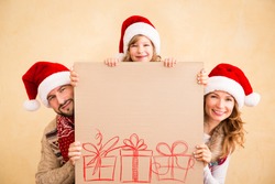 Happy family holding Christmas poster blank. Xmas holiday concept