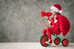 Happy child rides a retro bike. Kid playing at home. Christmas Xmas winter holiday concept