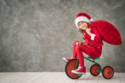 Happy child rides a bike. Kid playing at home. Christmas Xmas winter holiday concept