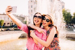 two pretty fresh hipster young brunette and blonde best friends girls,make selfie and having fun.