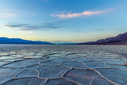 Badwater Basin at Sunset. Salt Crust and Clouds Reflection. Death Valley National Park. California, USA