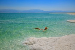 Girl relaxing in the water of Dead Sea