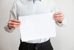 man in a white shirt holds a piece of paper to insert text mockup on a white background