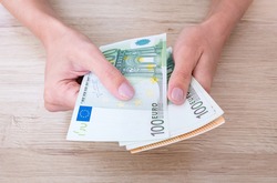 Euro cash in woman's hands.
