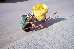 Janitor's cart with a broom, a dustpan, and various working tools for cleaning the street