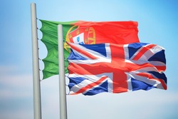 Portuguese and British flags amid blue skies