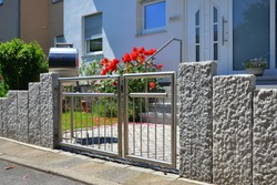 h-Grade Steel in a Granite Stone Garden Wall along the Road in Front of a residential Building