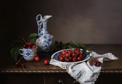 Still life with sweet cherries and vintage ceramic utensils