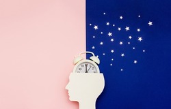 Silhouette of human and alarm clock on pink and blue backgrounds decorated with silver confetti. Human circadian rhythms concept. Copy space