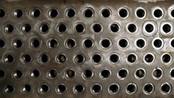 The texture of a metal product with holes. Metallic background with empty metal.