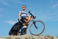 Bike ride. A young man on a bicycle with a dog