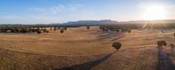 Agricultural land with mountains in the background at sunset - aerial panoramic landscape