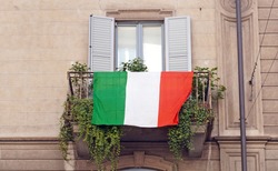  Europe, Italy , Milan - Flag of Italy hanging on the balcony of a house during n-cov19 Coronavirus epidemic emergency                              