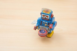 Vintage robot kids toy isolated on wood background. Kids toy. Vintage toy. Robot. Metal material toy.