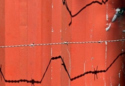 Red metallic surface and barbed wire