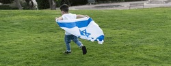 Young child running with Israeli flag. Rear view little boy running with Israel flag.